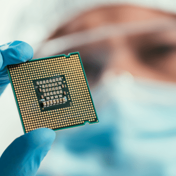 close-up of a gloved technician holding a semiconductor chip, representing advanced manufacturing at TSMC’s Arizona fab